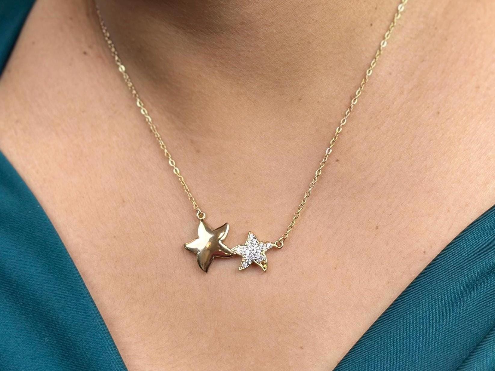 18K gold filled necklace with double star pendant on a model's neck. The stars are of different sizes sitting side by side.